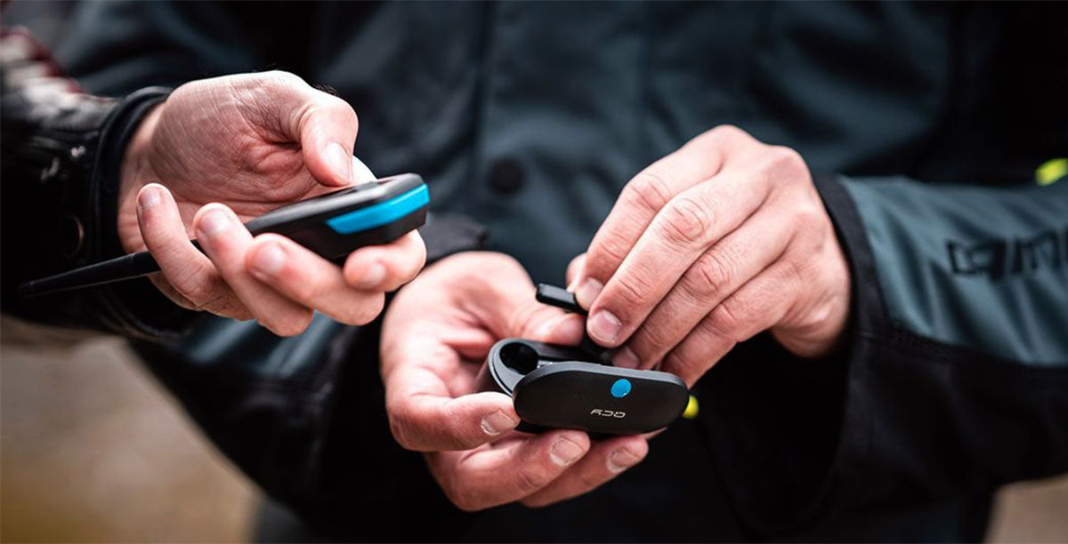 Sena MeshPort Blue Bluetooth to Mesh Intercom Adapter – two units held in hands for pairing - imagen 7