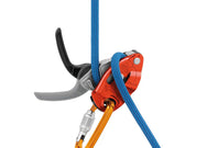 Red and orange Petzl GRIGRI belay device attached to a carabiner with a blue rope and a hand on the brake side - imagen 5