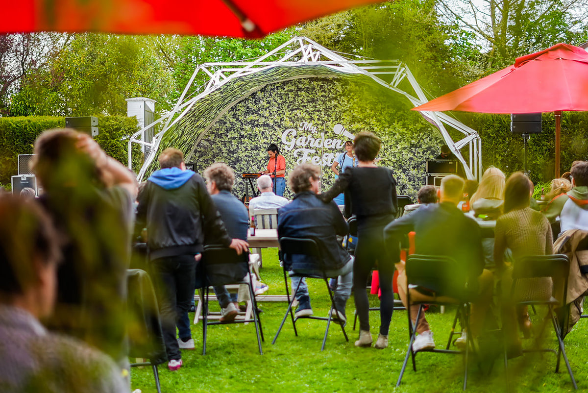 Konligo Fastival event structure with custom printed green foliage membrane and printed backdrop, hosting a live outdoor performance at My Garden Fest, now available on MTN SHOP US.