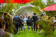 Konligo Fastival event structure with custom printed green foliage membrane and printed backdrop, hosting a live outdoor performance at My Garden Fest, now available on MTN SHOP US.
