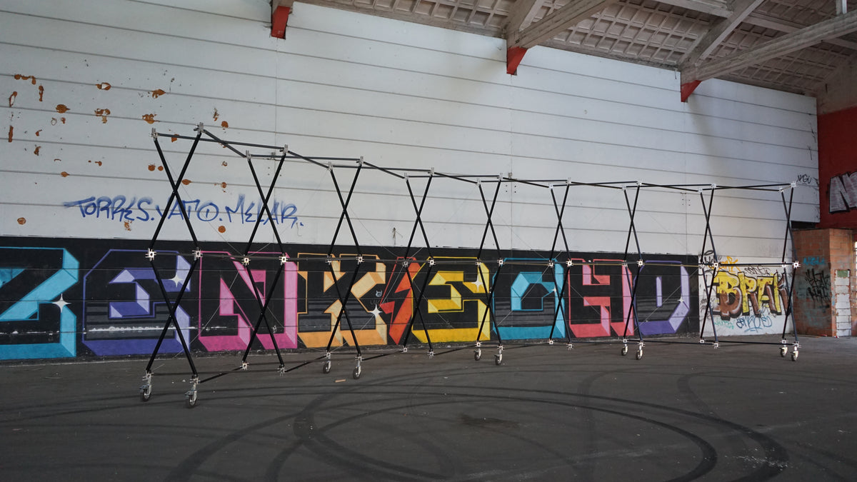 Estructura modular Konligo Luno Wall con ruedas instalada en el interior contra una pared de graffiti, ahora disponible en MTN SHOP US.