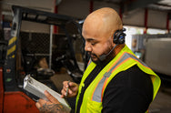Worker wearing Sena SPH10 headset in high-visibility vest on an industrial worksite - imagen 12